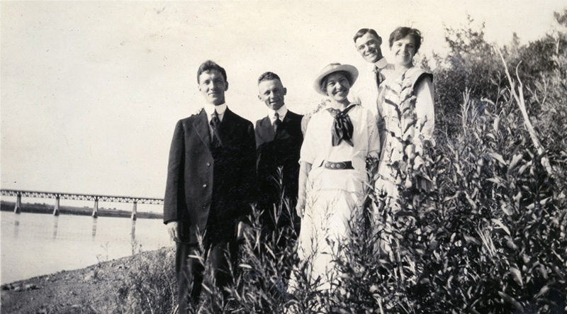 Nan McKay and Hope Weir are photographed with men on the riverbank in approximately 1915.