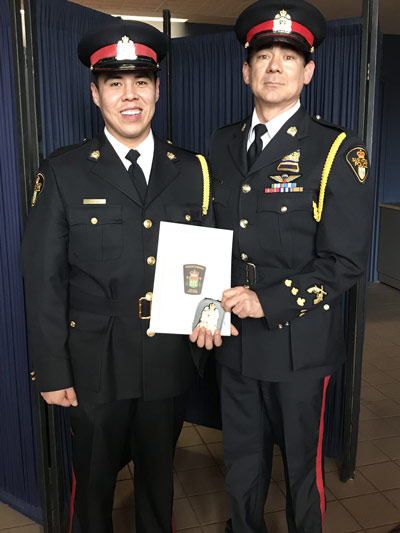 Retired Sgt. Joel Pedersen (right) presented John Langan with his Saskatoon Police Service badge in 2017. [icon image] Bianca Ermine
