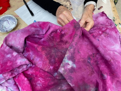hands stitching purple batik dyed fabric